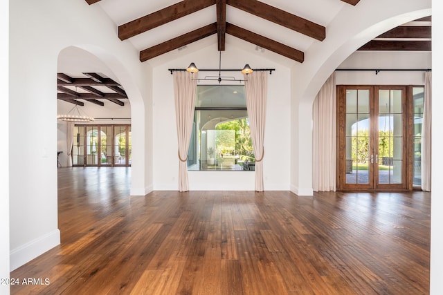 spare room featuring an inviting chandelier, french doors, dark hardwood / wood-style floors, and a healthy amount of sunlight