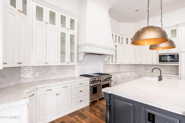 kitchen with sink, white cabinets, decorative light fixtures, double oven range, and premium range hood