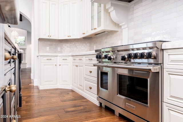 kitchen featuring white cabinets, tasteful backsplash, wood-type flooring, and double oven range