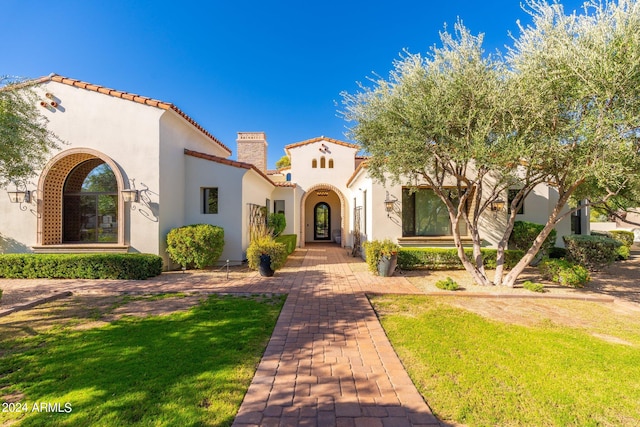 mediterranean / spanish home with a front yard