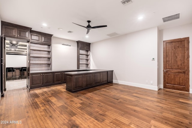 unfurnished office with ceiling fan and dark hardwood / wood-style flooring