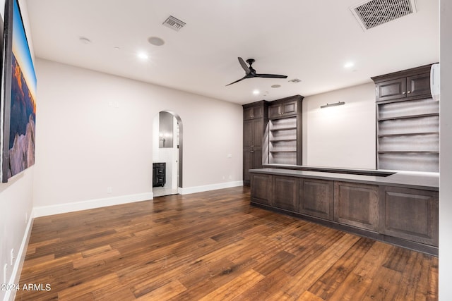 unfurnished living room featuring ceiling fan and dark hardwood / wood-style flooring