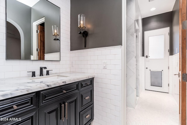 bathroom with vanity, tile walls, and tile patterned flooring