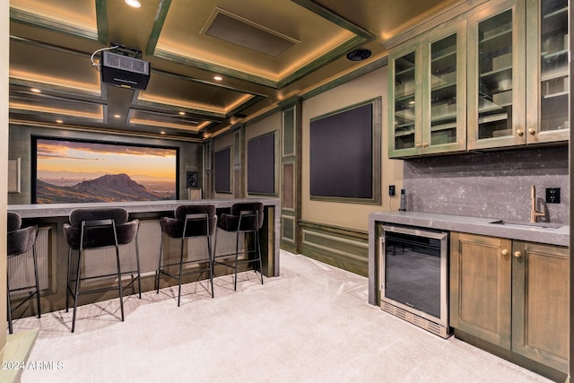 home theater with beam ceiling, wet bar, light carpet, coffered ceiling, and wine cooler