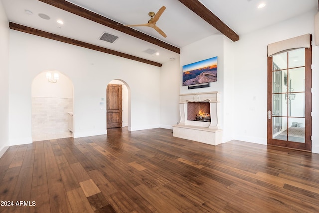 unfurnished living room with ceiling fan, beamed ceiling, and dark hardwood / wood-style flooring