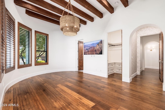 spare room with dark wood-type flooring, beamed ceiling, and a chandelier