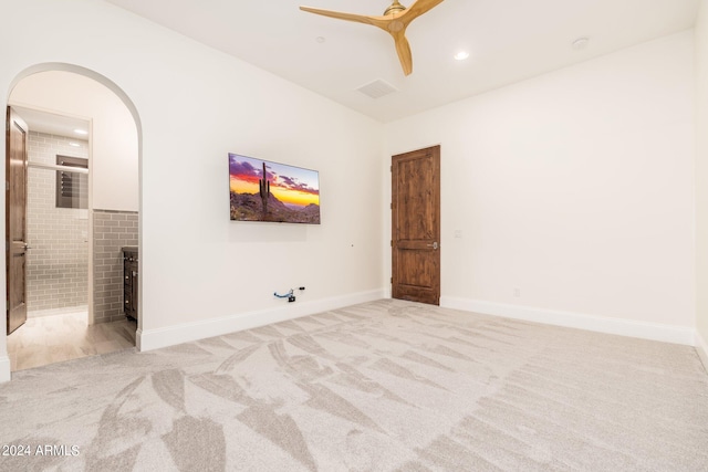 carpeted spare room featuring ceiling fan