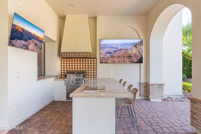 view of patio / terrace with a grill, exterior bar, and area for grilling