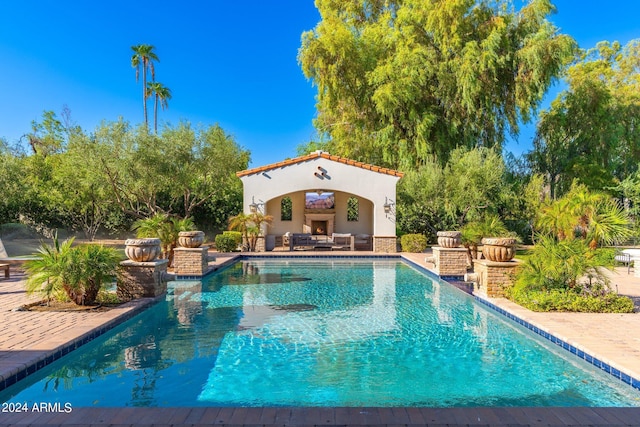 view of pool with a patio and an outdoor fireplace