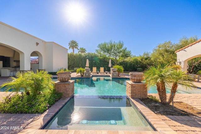 view of pool with an in ground hot tub and a patio area