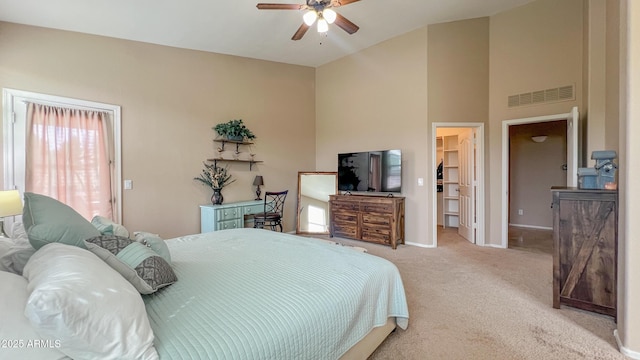 bedroom with a walk in closet, visible vents, carpet flooring, baseboards, and ceiling fan