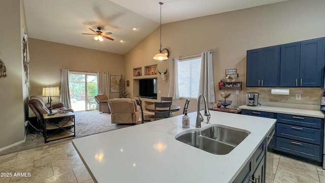 kitchen featuring open floor plan, blue cabinetry, light countertops, and a sink