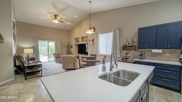 kitchen featuring blue cabinetry, ceiling fan, open floor plan, light countertops, and a sink