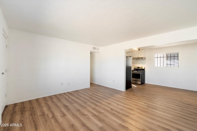 unfurnished living room featuring visible vents and light wood-type flooring