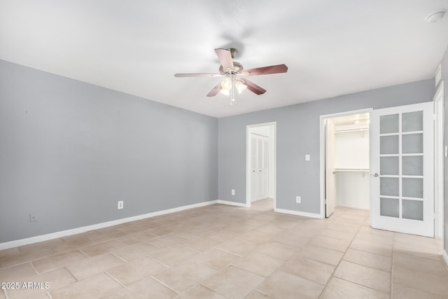 unfurnished bedroom featuring french doors, ceiling fan, light tile patterned floors, a spacious closet, and a closet