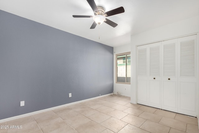 unfurnished bedroom featuring ceiling fan, a closet, and light tile patterned flooring