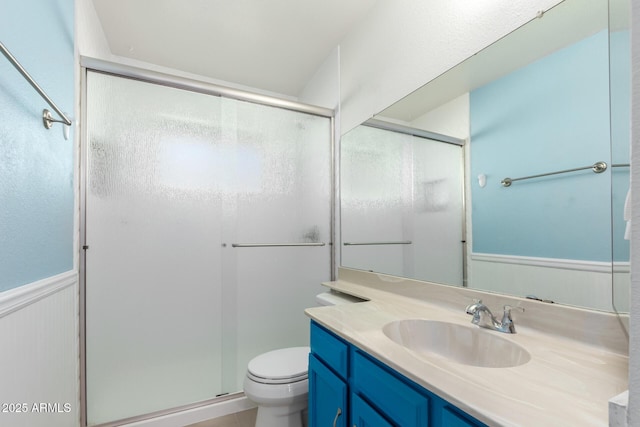 bathroom with toilet, an enclosed shower, and vanity