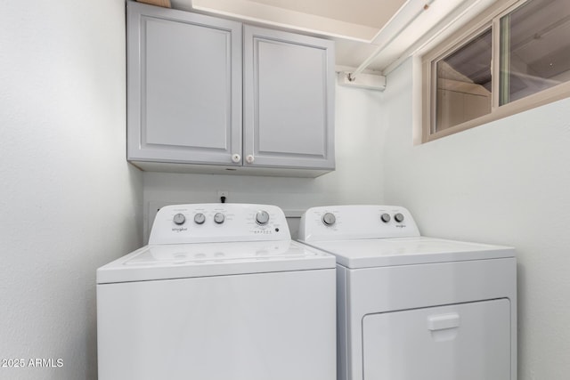 laundry area featuring washer and dryer and cabinets