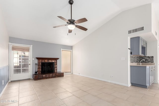 unfurnished living room featuring ceiling fan, lofted ceiling, and light tile patterned floors