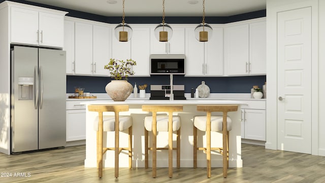 kitchen featuring decorative light fixtures, appliances with stainless steel finishes, a kitchen breakfast bar, and white cabinetry