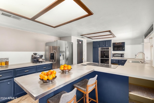 kitchen with sink, kitchen peninsula, a kitchen breakfast bar, black appliances, and blue cabinets