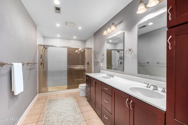 bathroom featuring vanity, tile patterned flooring, toilet, and an enclosed shower