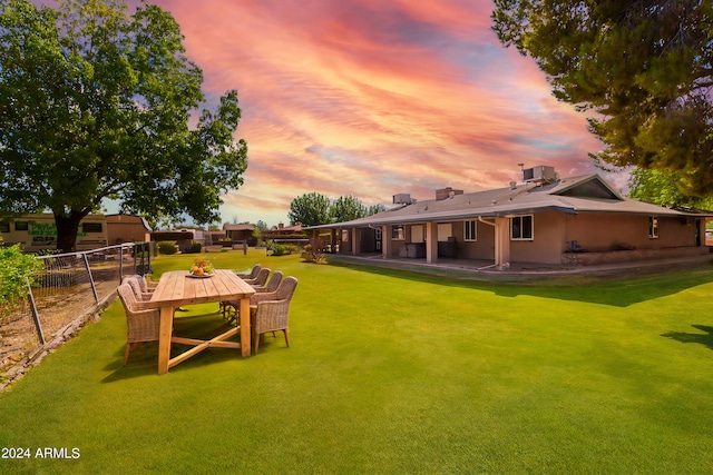 yard at dusk featuring a patio