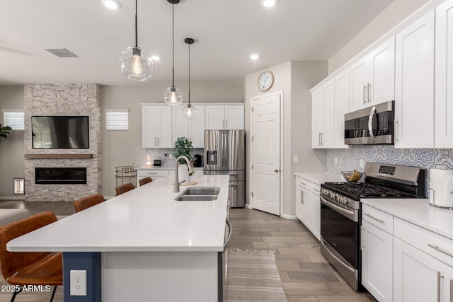 3081 E Desert Broom Pl, Chandler, AZ 85286 - kitchen with stainless steel appliances, a sink, open floor plan, tasteful backsplash, and light countertops