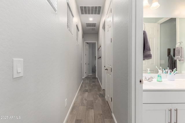 3081 E Desert Broom Pl, Chandler, AZ 85286 - hallway featuring a sink, wood finished floors, and baseboards