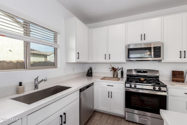 kitchen featuring white cabinetry, appliances with stainless steel finishes, sink, and light hardwood / wood-style floors