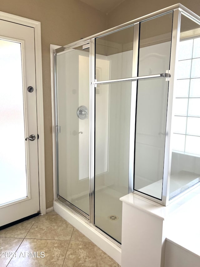 bathroom featuring a shower with shower door and tile patterned flooring