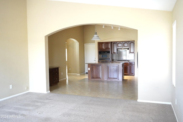 kitchen with decorative light fixtures, light tile patterned floors, appliances with stainless steel finishes, and a kitchen island