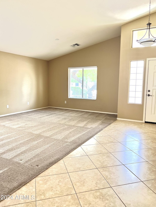 tiled entryway with vaulted ceiling