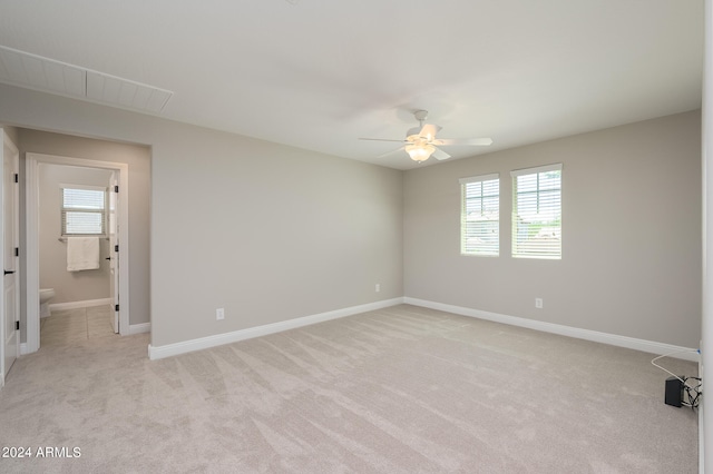 carpeted spare room featuring ceiling fan