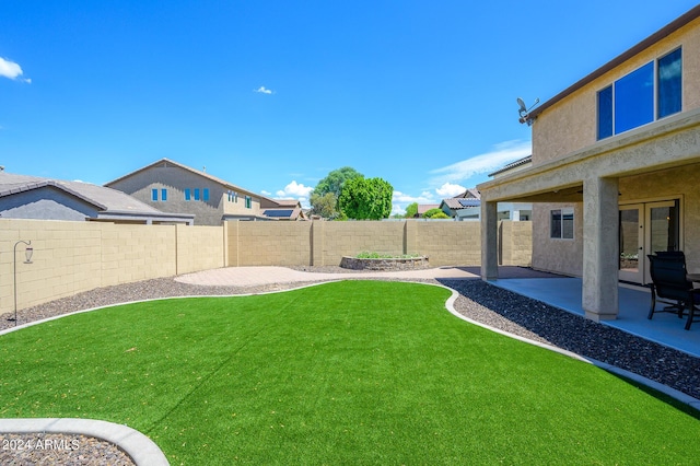 view of yard featuring a patio, a fenced backyard, and french doors
