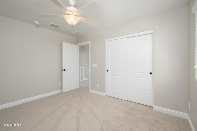 unfurnished bedroom with carpet, baseboards, ceiling fan, visible vents, and a closet