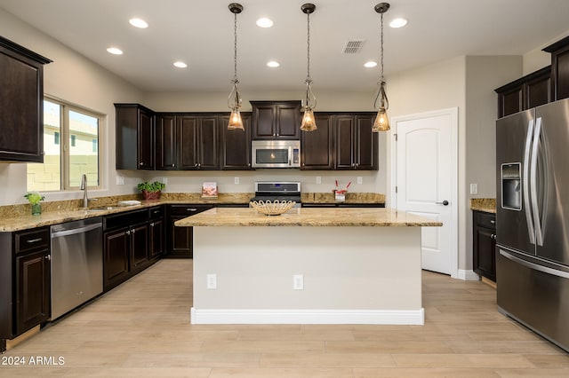 kitchen featuring sink, dark brown cabinets, appliances with stainless steel finishes, and a kitchen island