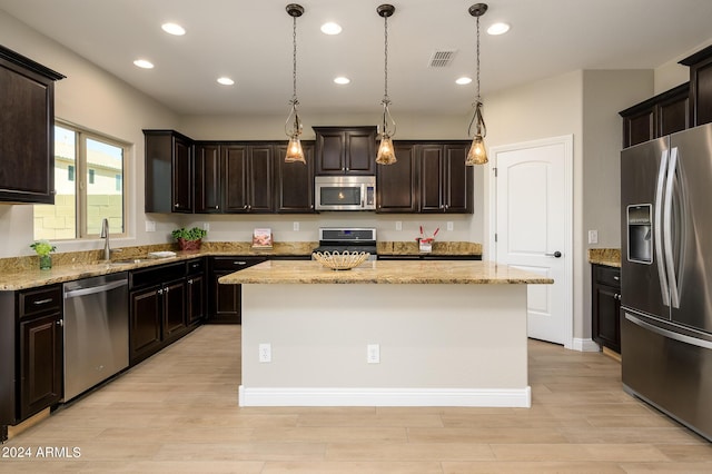 kitchen with a sink, appliances with stainless steel finishes, light wood-type flooring, visible vents, and dark brown cabinets