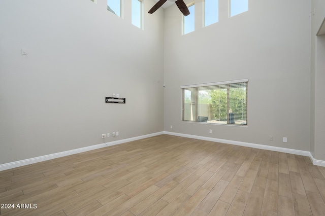 unfurnished room with baseboards, ceiling fan, a healthy amount of sunlight, and light wood finished floors