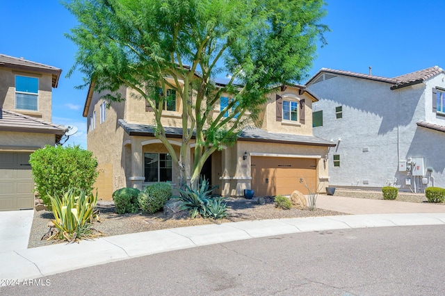 view of front facade featuring a garage, stucco siding, solar panels, a tile roof, and driveway