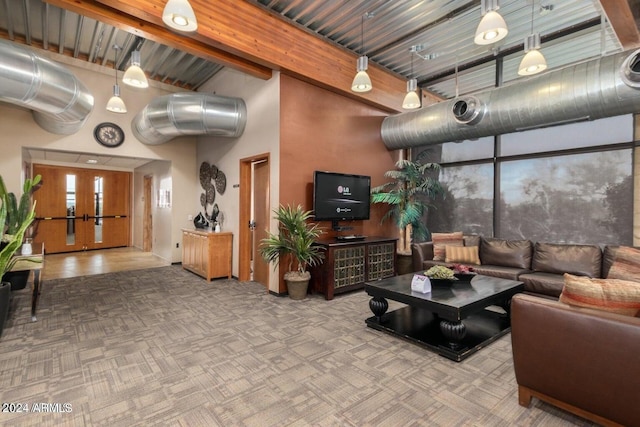 carpeted living area with a high ceiling and beam ceiling