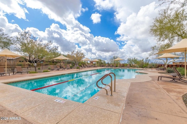 community pool with fence and a patio