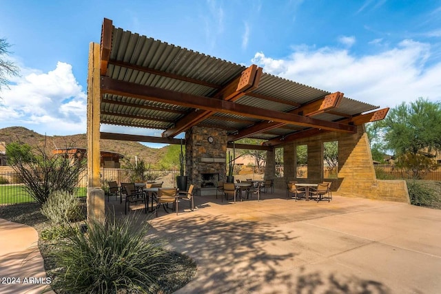 view of patio / terrace featuring a mountain view and an outdoor stone fireplace