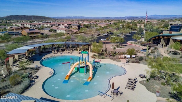 view of swimming pool with a water play area, a residential view, and a mountain view