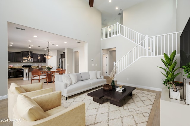 living room with light wood-type flooring and a high ceiling