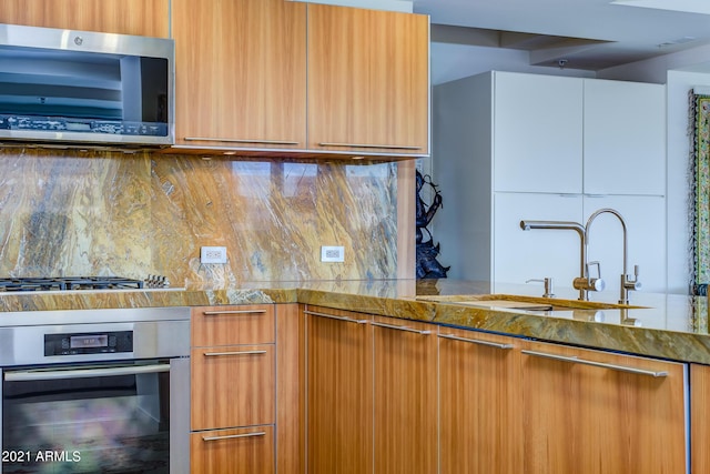 7161 E Rancho Vista Dr Unit 6001, Scottsdale, AZ 85251 - kitchen with stone counters, modern cabinets, decorative backsplash, stainless steel appliances, and a sink