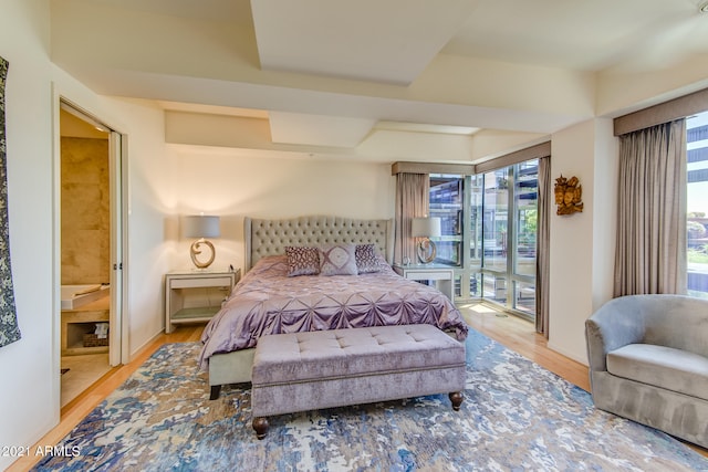 bedroom featuring ensuite bath and light hardwood / wood-style flooring