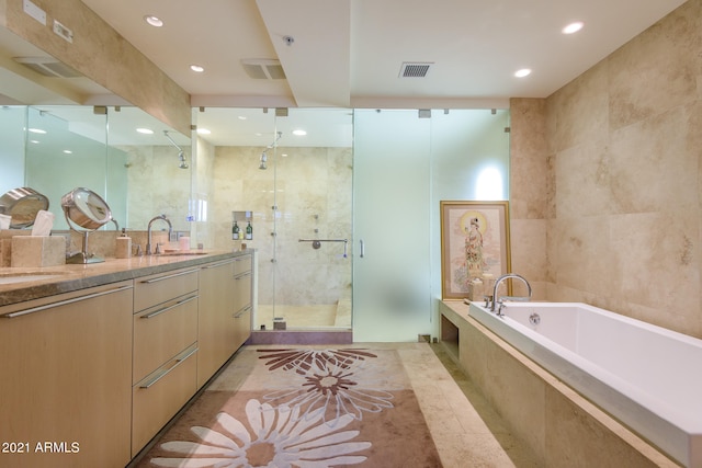 bathroom with independent shower and bath, vanity, and tile walls