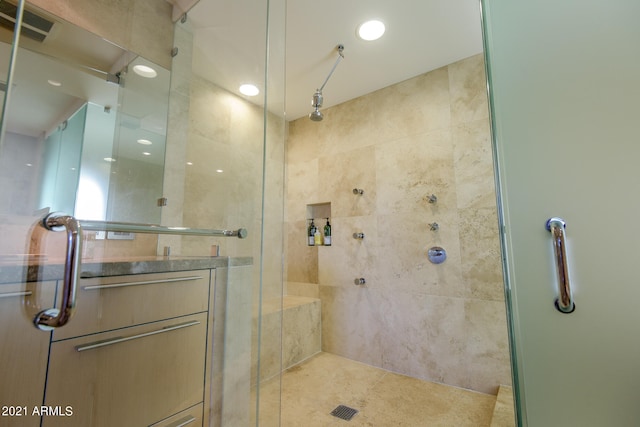 bathroom with tile patterned floors, a shower with door, and vanity