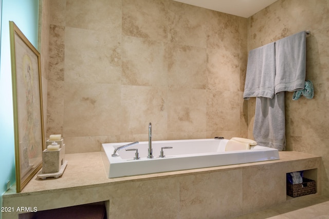 bathroom with tile walls and tiled tub